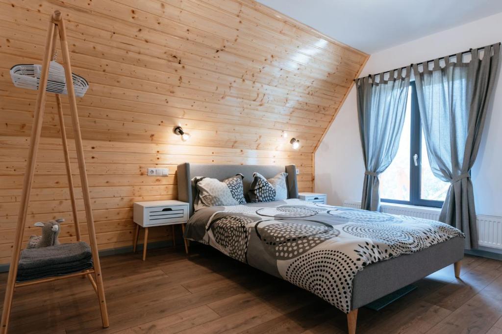 a bedroom with a wooden wall with a bed at Wild Cabin in Malaia