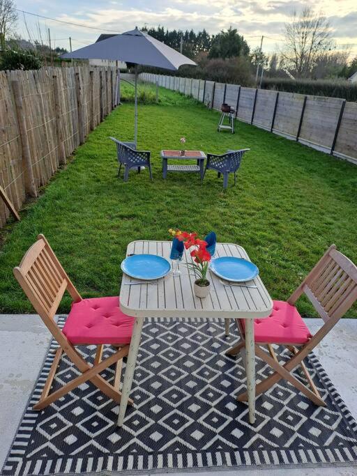 - une table de pique-nique avec 2 chaises et une table fleurie dans l'établissement Ôcalme, Idéal à 2, jardin, plage, à Bréhal