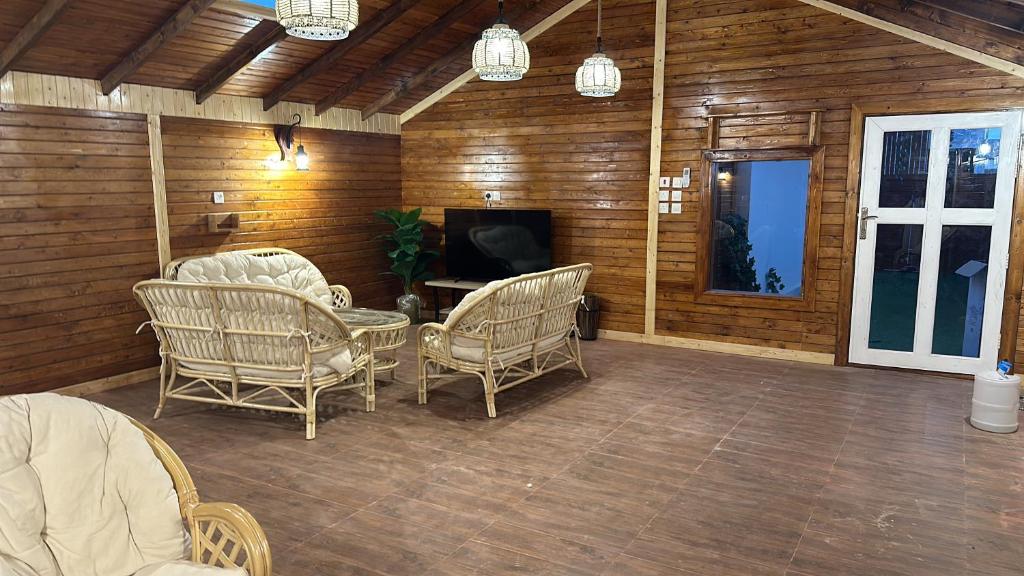 a screened in porch with chairs and a television at نجد هاوس - نساء فقط Ladies Hostel in Riyadh