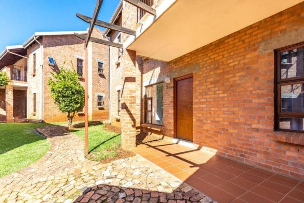 a brick house with a cross on the side of it at 3-Bedrooms Apartment in Bushmill Amorosa in Roodepoort