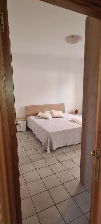 sypialnia z łóżkiem i podłogą wyłożoną kafelkami w obiekcie Le Fortezze w mieście Viterbo