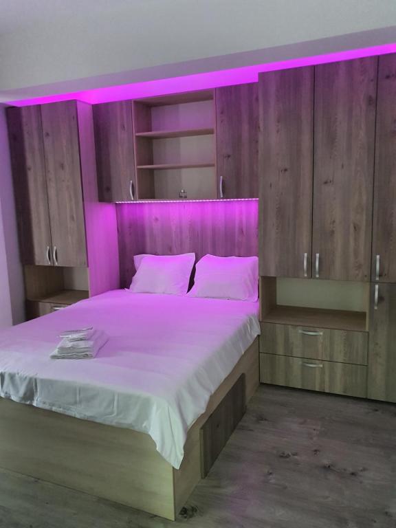 um quarto com uma cama grande e iluminação roxa em Angi House Otopeni em Otopeni