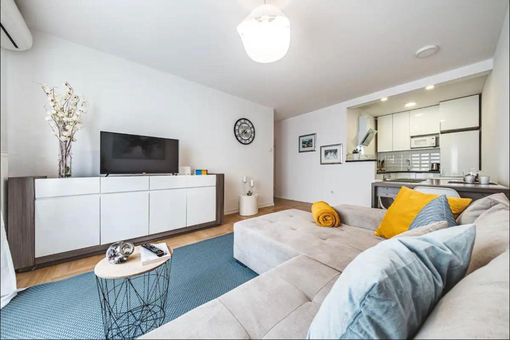 ein Wohnzimmer mit Sofa und Fernseher in der Unterkunft Apartman Gold Oasis, self service check-in in Zagreb