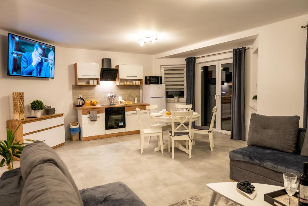 a living room with a couch and a table and a kitchen at Apartamenty ,,Górska Strefa'' Czorsztyn in Czorsztyn