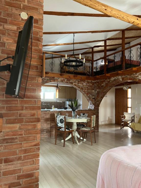 a living room with a brick wall and a dining room at Kamera House in Khordhákion