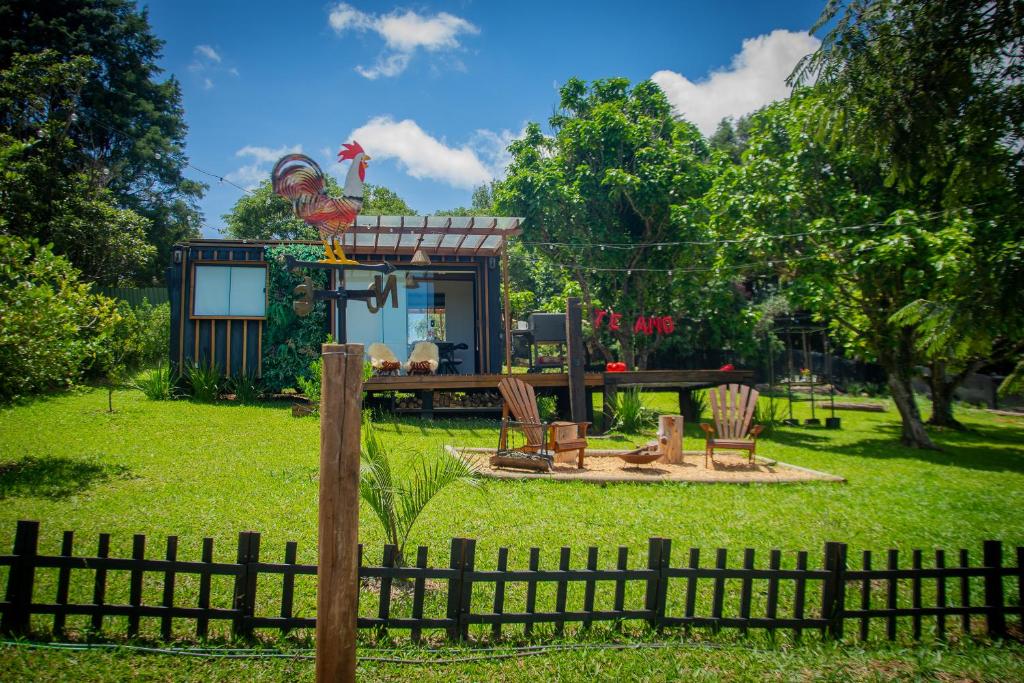 een klein huis met een tafel en stoelen in een tuin bij T24 Tinyhouse Container in Ibiúna
