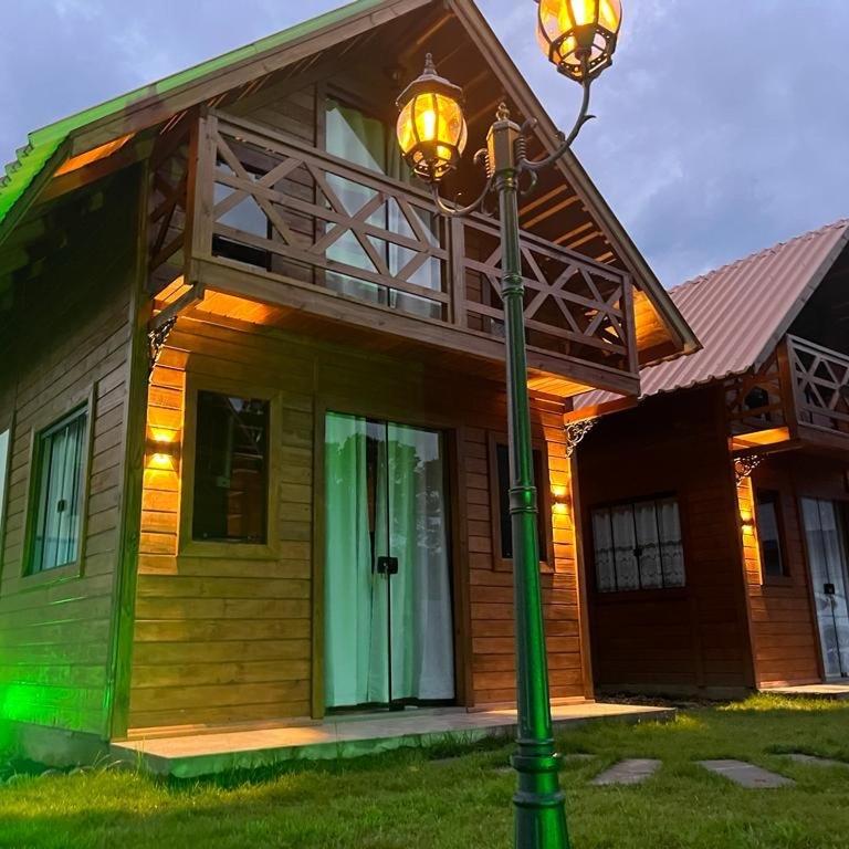 a house with a light pole in front of it at Pousada Chalé Flor de Hibisco 2 in Penha