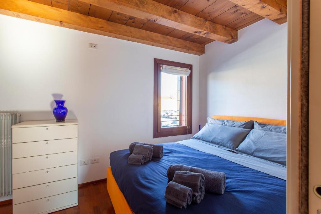 een slaapkamer met een blauw bed en een raam bij Comodo Apt Centrale in Treviso