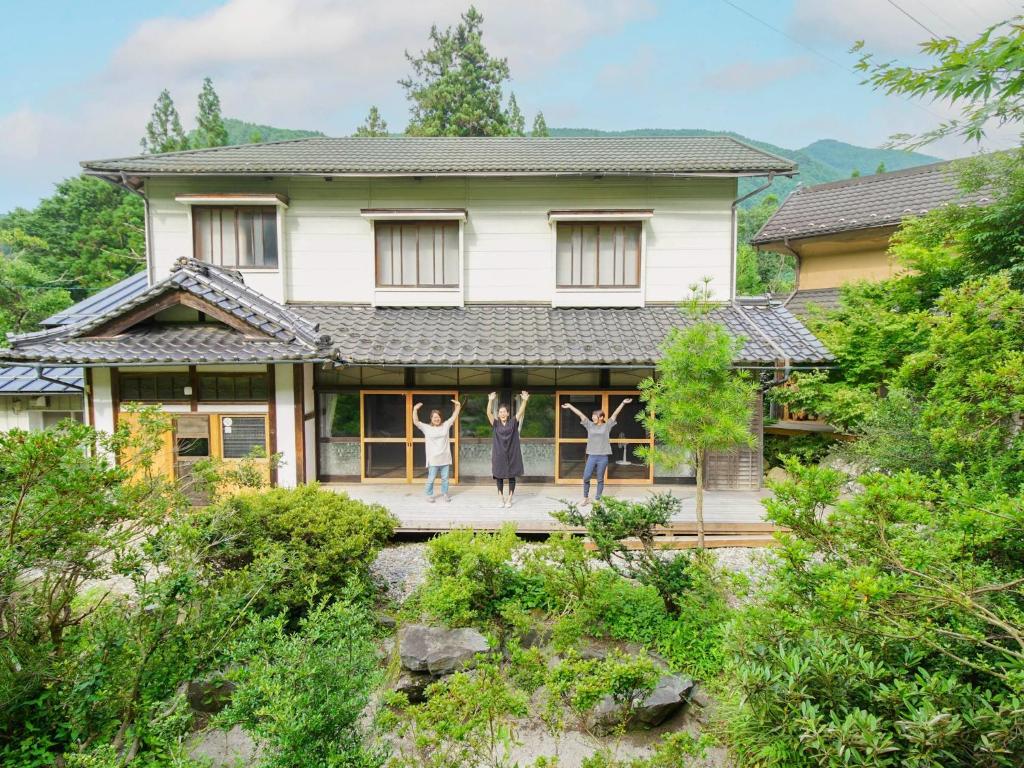 um grupo de pessoas de pé na varanda de uma casa em Gonomori main building - Vacation STAY 24252v em Nagano