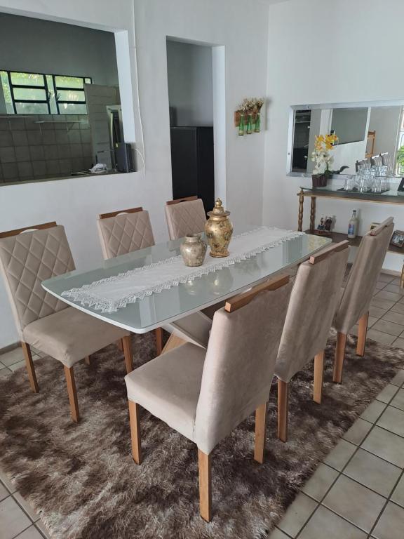 uma mesa de jantar e cadeiras com uma tampa de vidro em Casa aconchegante na zona leste em Teresina