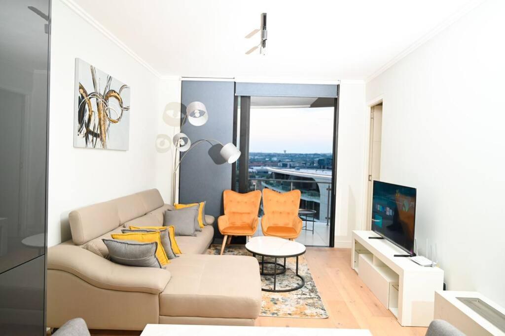 ein Wohnzimmer mit Couch und Fernseher in der Unterkunft Elegant-World Ellipse Waterfall in Midrand