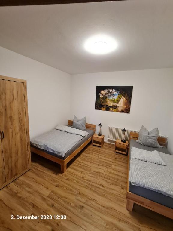 2 camas en una habitación con suelo de madera en Handwerkerwohnung, Monteurunterkunft-Rodgau, en Rodgau