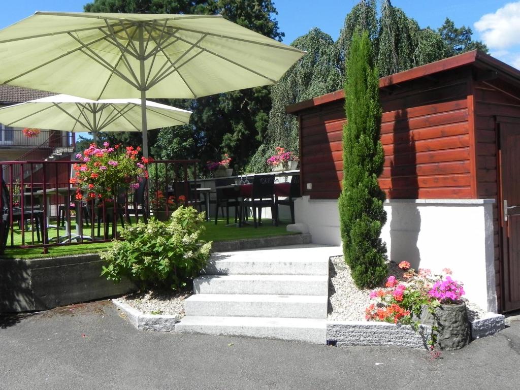 un conjunto de escaleras con sombrilla y flores en Hôtel Restaurant Le Moschenross, en Thann