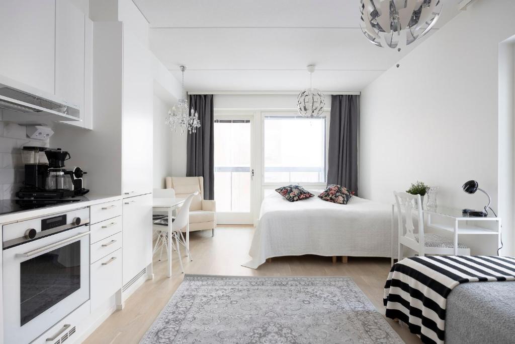 cocina blanca y sala de estar con cama en City Island Studio Apartment, 4 beds, free street parking with parking disc, bus stop 200m, en Helsinki