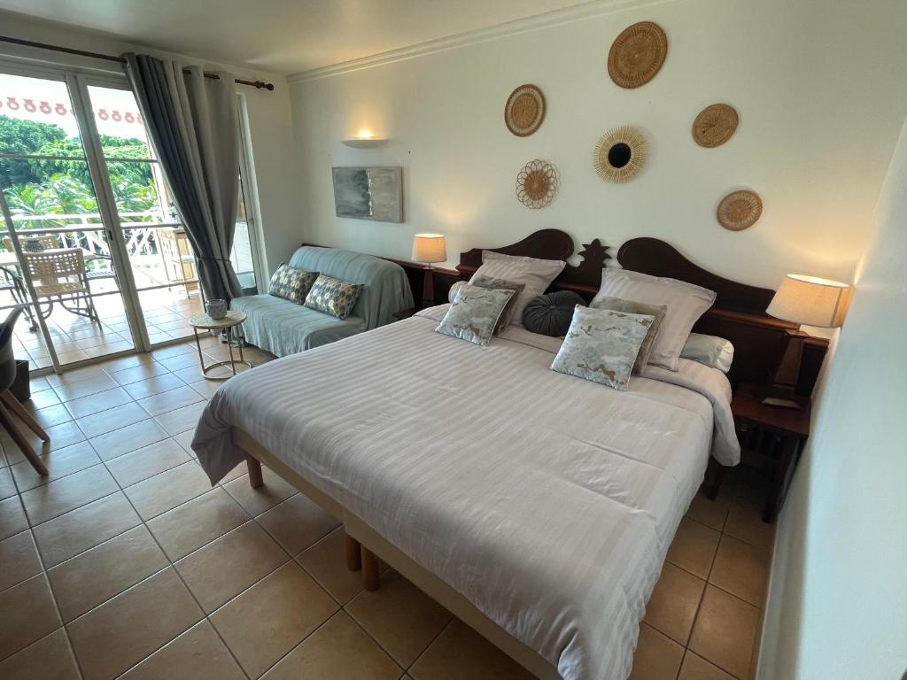 a bedroom with a large bed and a living room at Studio Charme et cosy à Sainte-Luce Martinique in Sainte-Luce