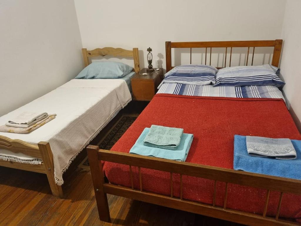 Dos camas en una habitación con toallas. en Hotel Cuba en Buenos Aires
