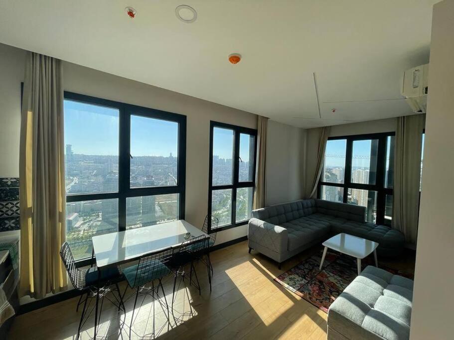 sala de estar con sofá y ventanas grandes en Furnished APT (29th floor) with panoramic views, en Esenyurt