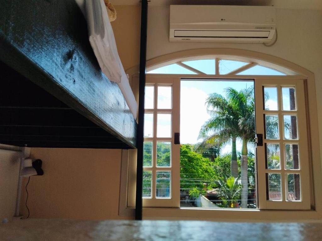 una ventana abierta con vistas a una palmera en Santa Catarina Hostel en Florianópolis