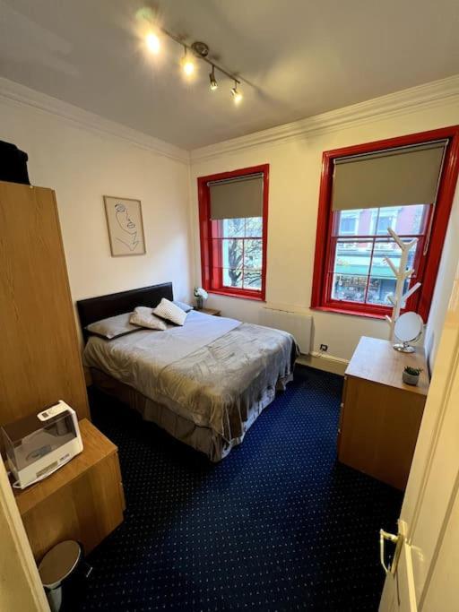 una camera d'albergo con un letto e due finestre di Flat in Central London a Londra