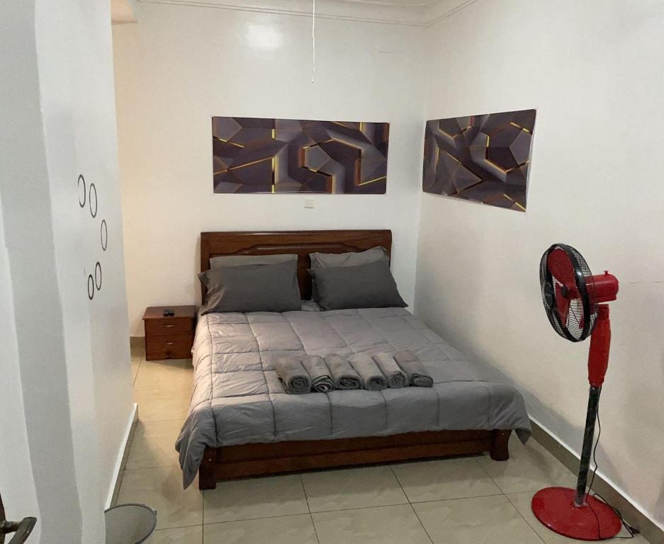 吉佳利的住宿－Budget Retreat Kiyovu，卧室配有一张床,墙上挂有两幅画