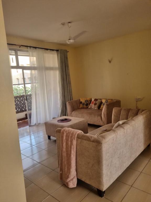 een woonkamer met 2 banken en een tafel bij KMA APARTMENTS BLOCK 10-3 in Mtwapa