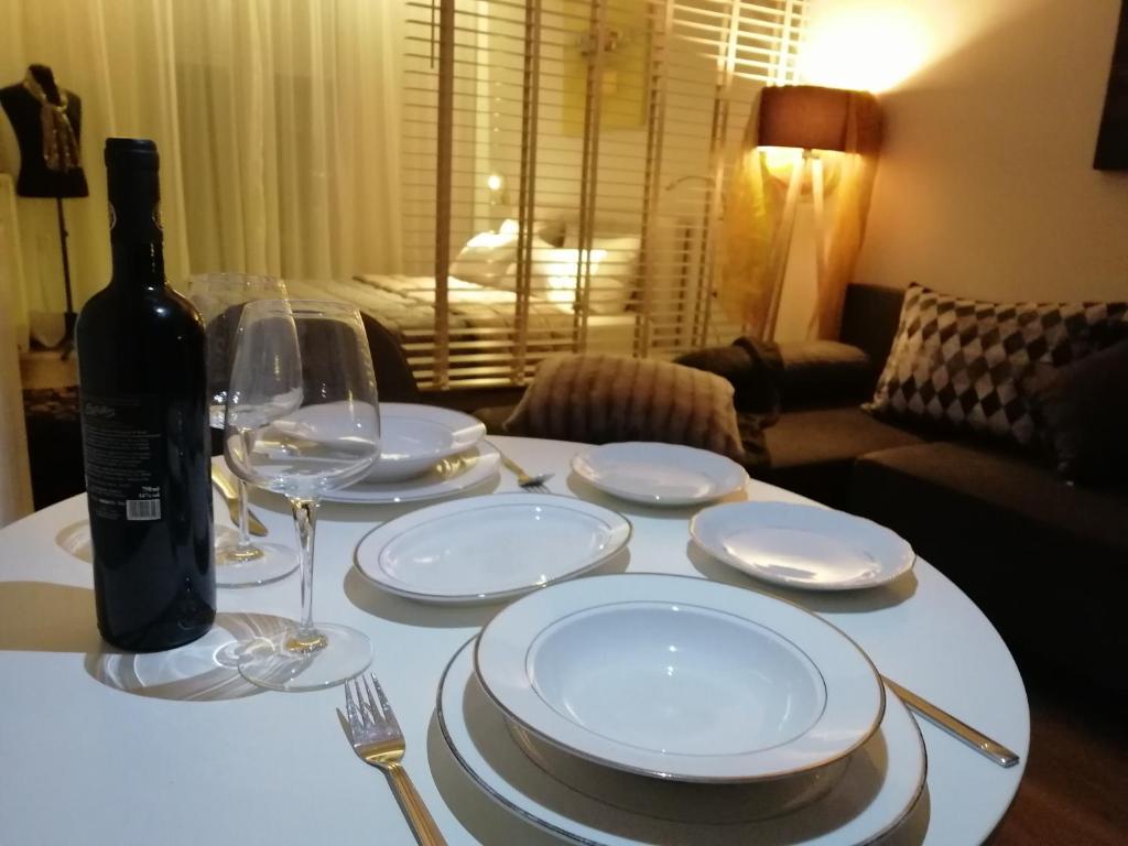 a table with plates and glasses and a bottle of wine at Central suite on Clock Square D1 in Veria