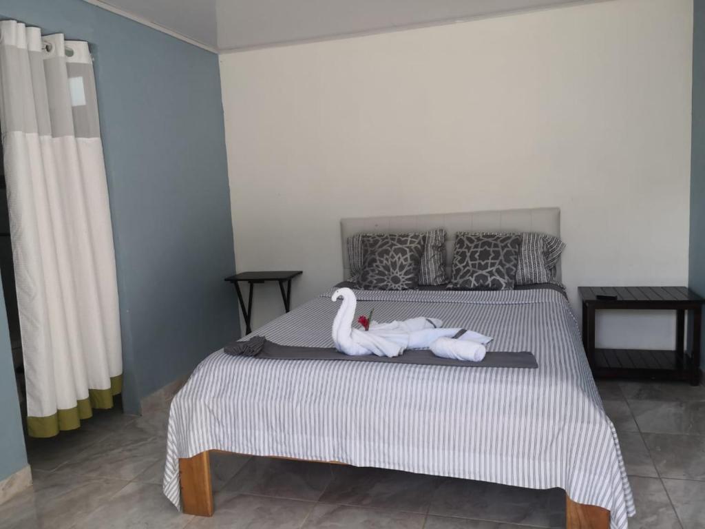 una camera da letto con un letto con due cigni sopra di Villa el paraíso a San José