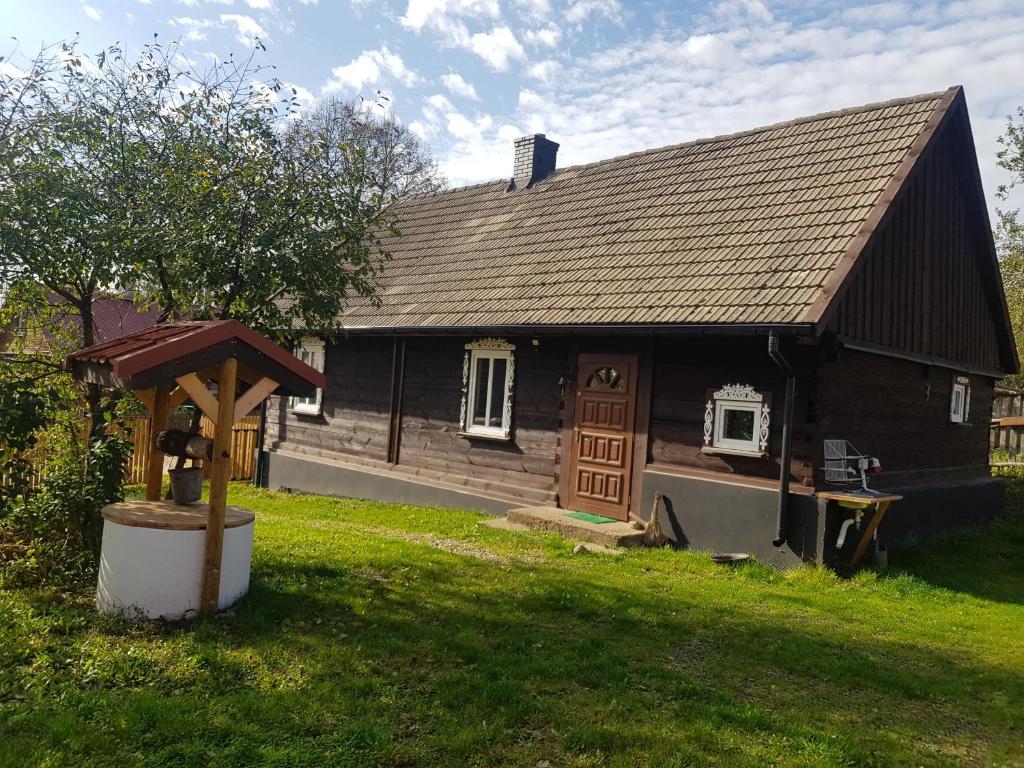 a large wooden house with a tree in the yard at Skroblakówka 