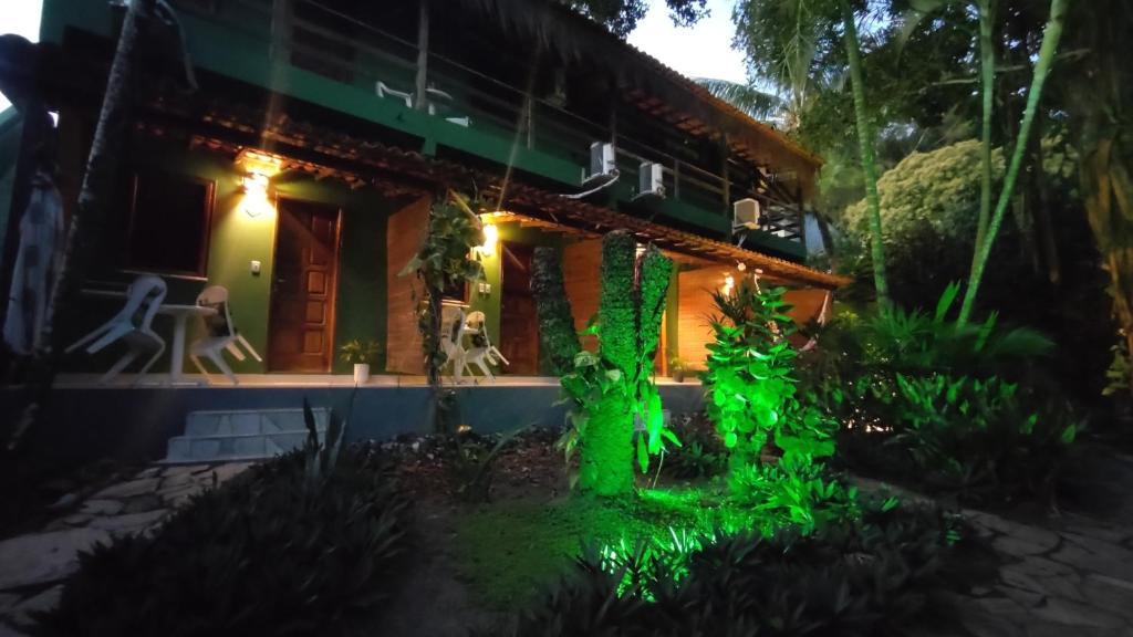 una casa iluminada por la noche con luces verdes en Pousada Sossego, en Isla de Boipeba