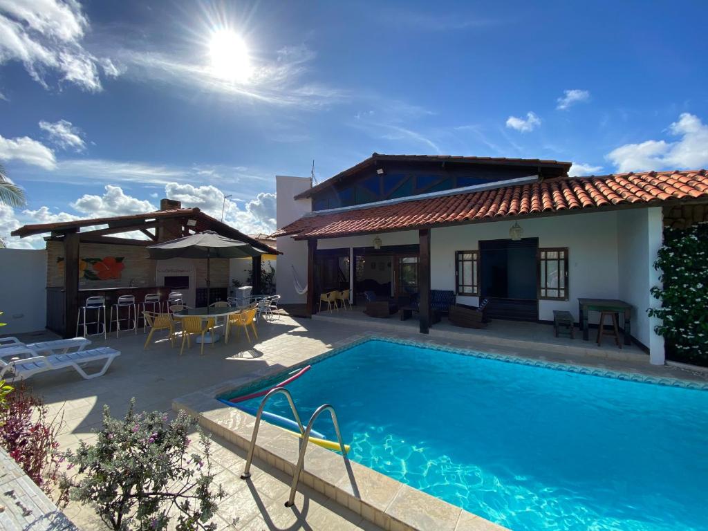 une villa avec une piscine et une maison dans l'établissement Casa Familiar 5 Suítes Porto de Galinhas, à Porto de Galinhas