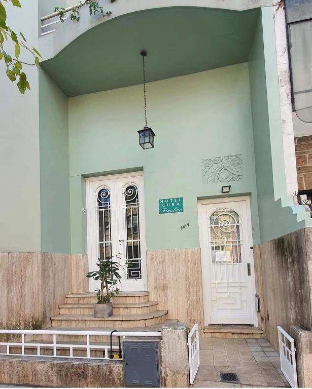 a building with a white door and a potted plant at Hotel Cuba in Buenos Aires
