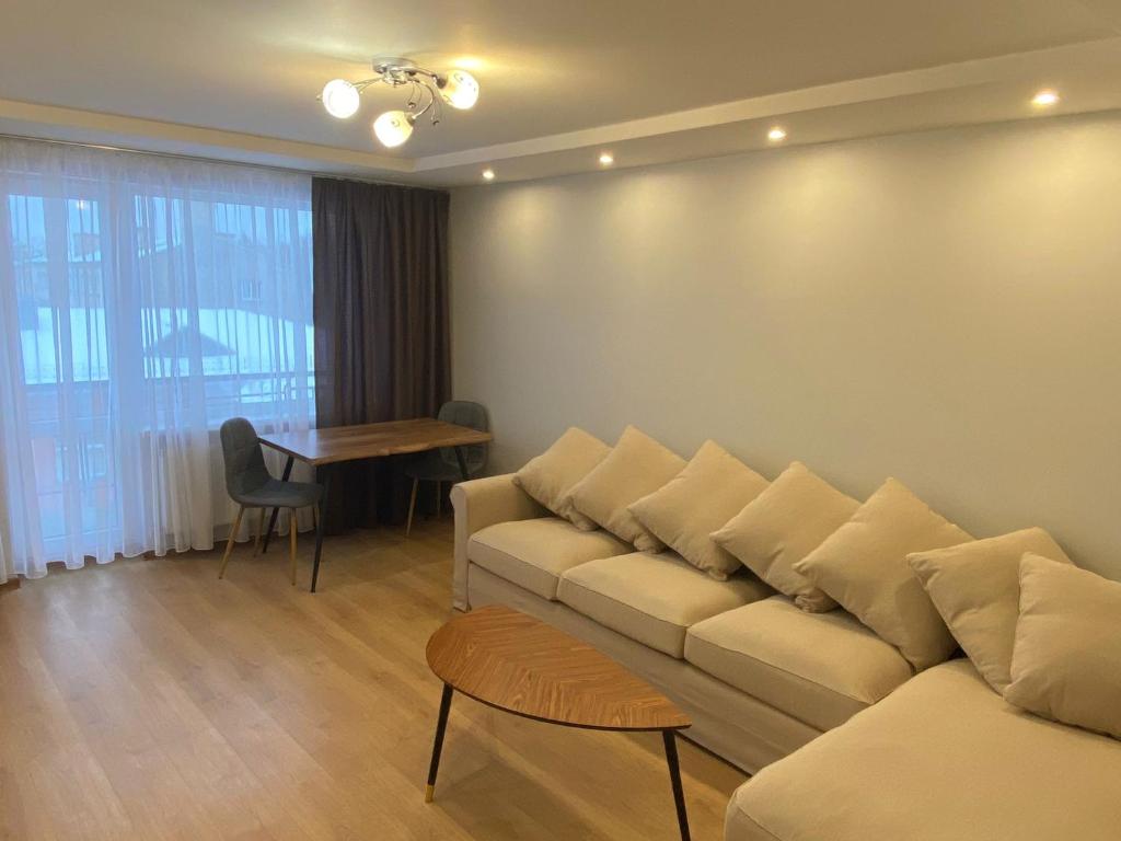 a living room with a couch and a table at Rezekne Cozy Stay in Rēzekne