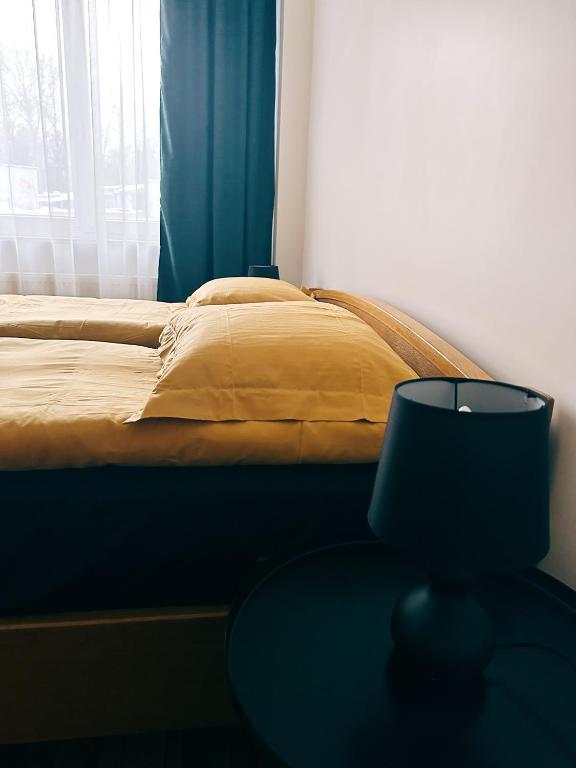 a bedroom with a bed and a table with a lamp at City Center Apartments in Vilnius