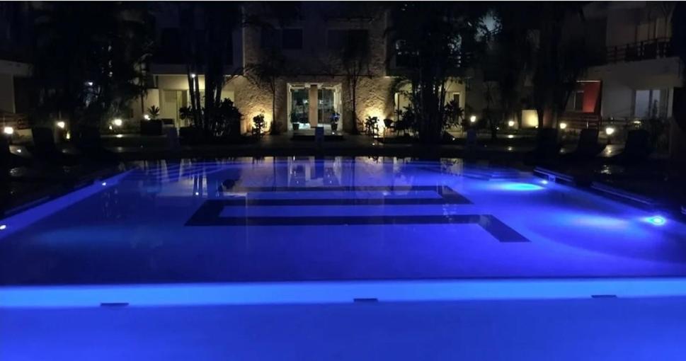 uma grande piscina à noite com luzes azuis em BLUE OCEAN RIVIERA MAYA em Playa del Carmen