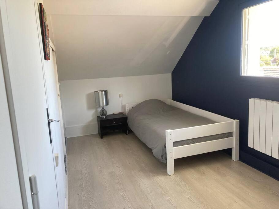 1 dormitorio con cama y pared azul en Maison au calme, en Nazelles