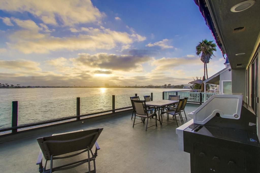 a balcony with a table and chairs and the water at Mission Bay Dreams - w Bay Access, Parking, Pool & Spa in San Diego