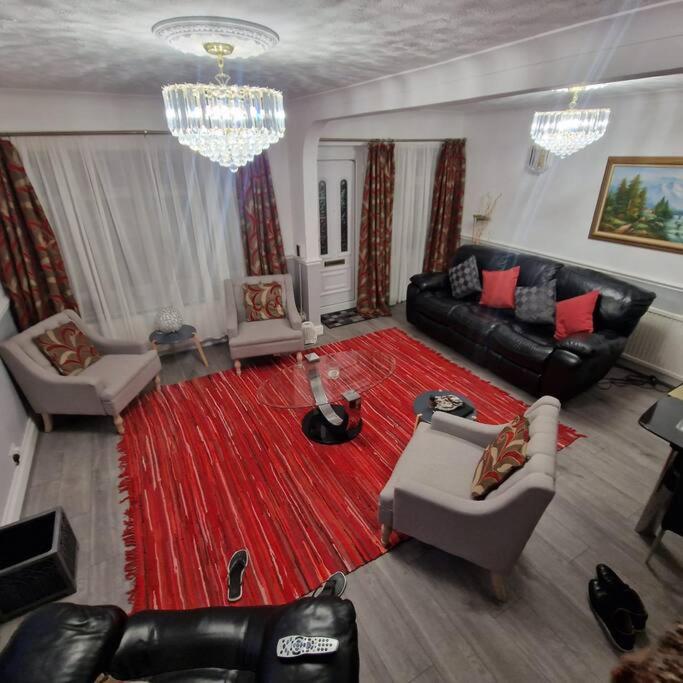 a living room with a couch and a red rug at 5 Bedroom Luxury Home with Garden in East London in Wanstead