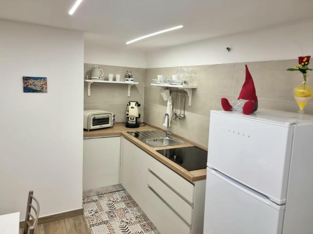 uma cozinha com um frigorífico branco e um lavatório em Casa comoda e centrale in quartiere storico di Napoli em Nápoles