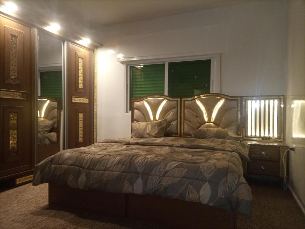 Un dormitorio con una cama grande y una ventana en شقق مدن الديكابوليس en Irbid