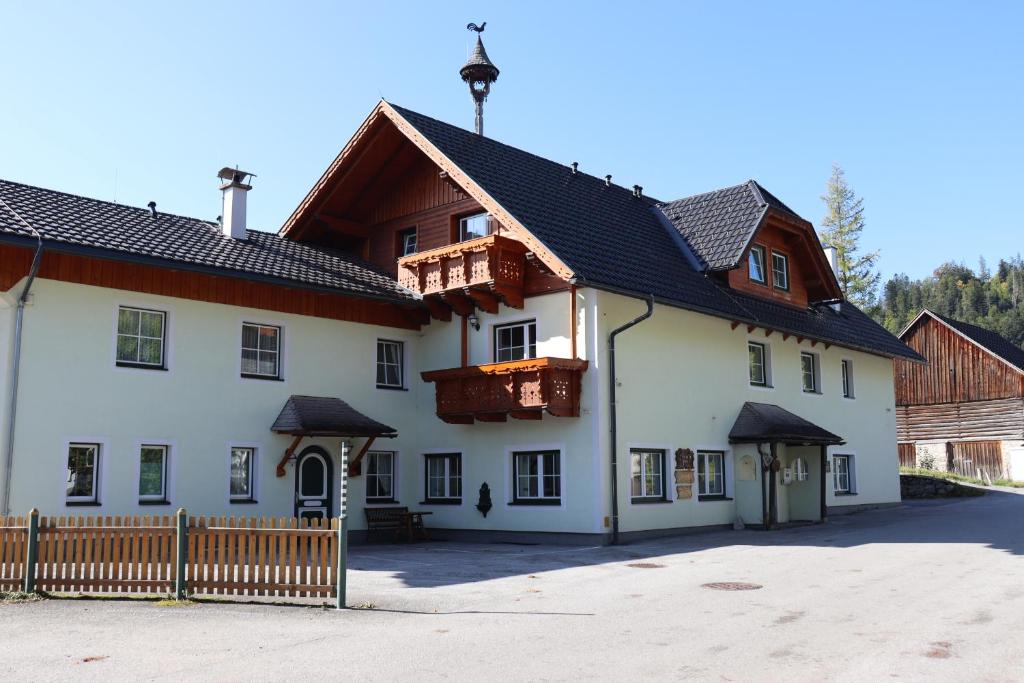 Apartman Tauplitz skiing, hiking, bike, cross country - Haus Sandlweber في Obersdorf: مبنى ابيض كبير مع سور خشبي