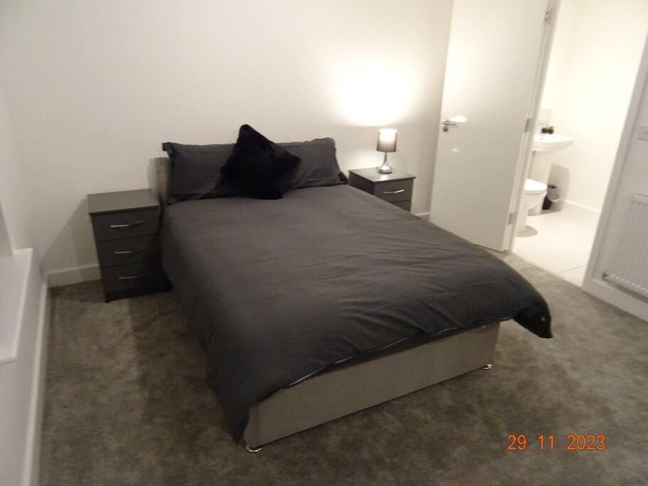 um quarto com uma cama com um edredão preto em Beautiful 4 bed house in Leeds em Cross Gates
