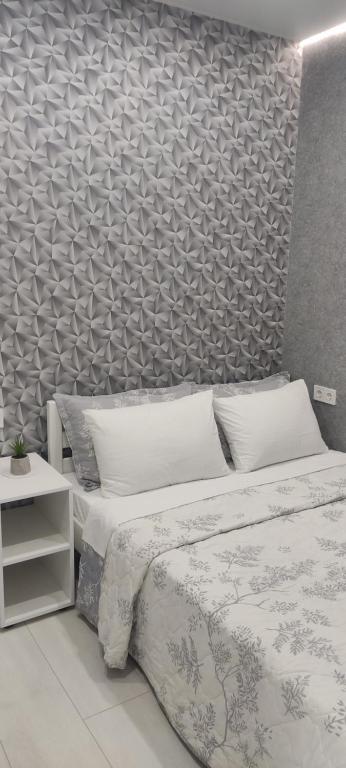 a bedroom with a bed and a wall at Malinki in Odesa