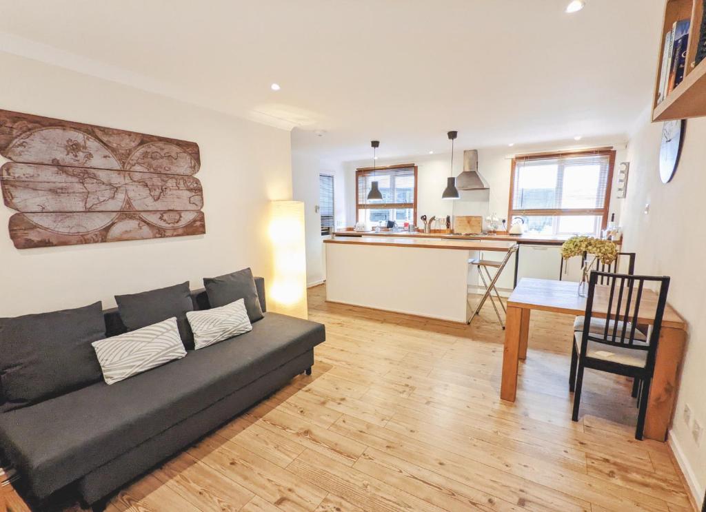a living room with a couch and a kitchen at Newly Refurbished in Town Center in St Andrews