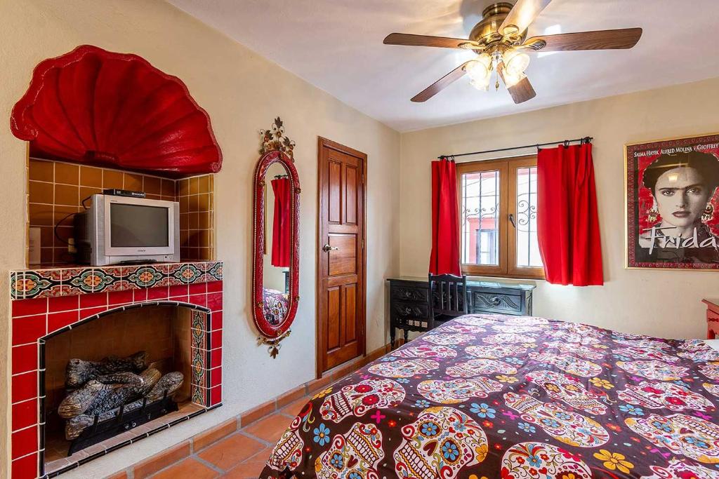 Schlafzimmer mit einem Bett, einem Kamin und einem TV in der Unterkunft San Miguel Actor's Studios in San Miguel de Allende