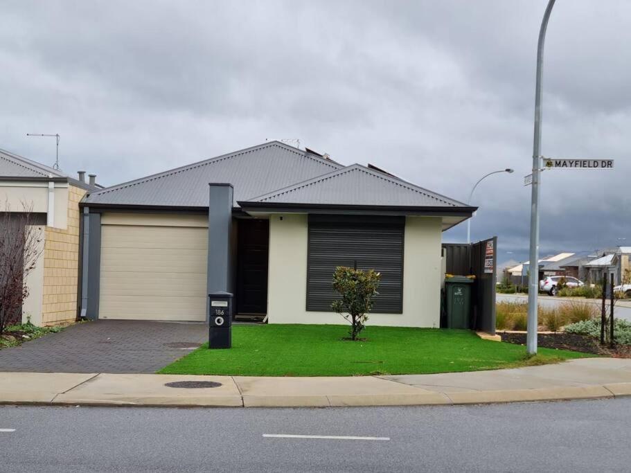 a house on a street with a green lawn at Spectacular 3 Bedroom, 2 Bathroom Home. in West Swan