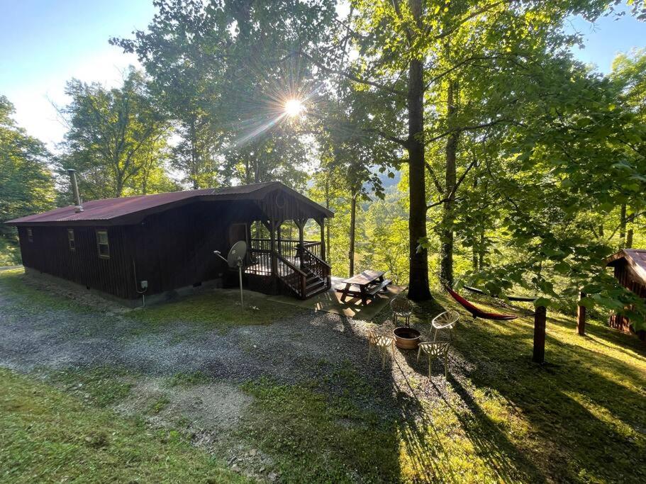 a cabin in the middle of a field with trees at Getaway to a very private beautiful Cabin. in Kyles Ford