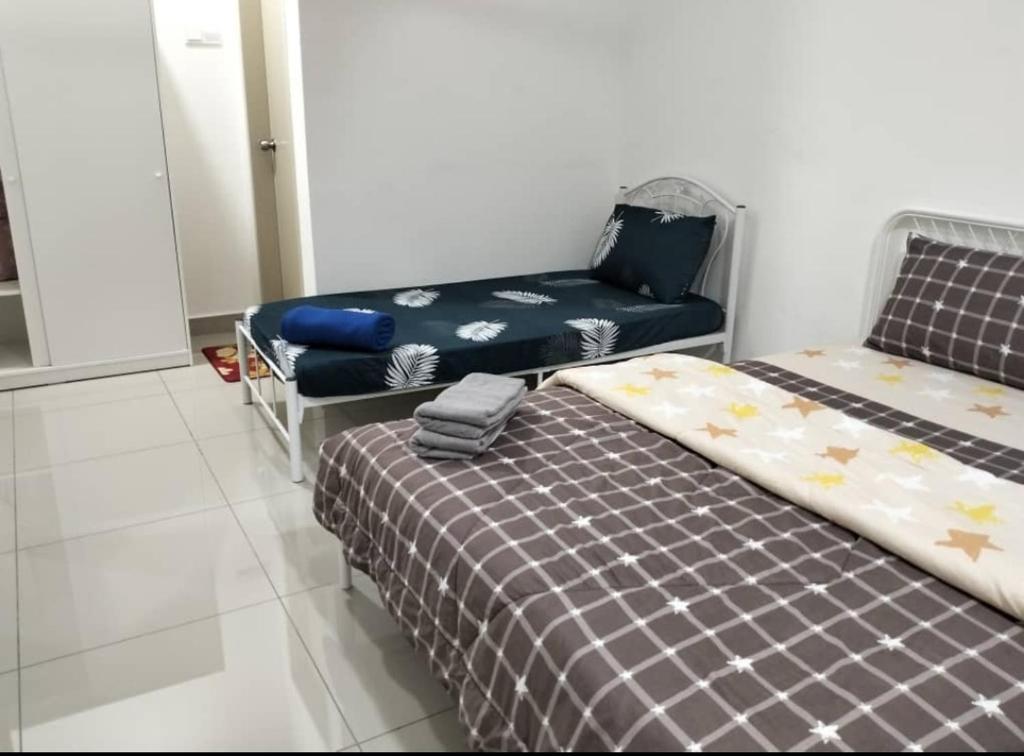 ein Zimmer mit 2 Betten und einem Stuhl darin in der Unterkunft Mutiara Bali Residence Melaka in Malakka
