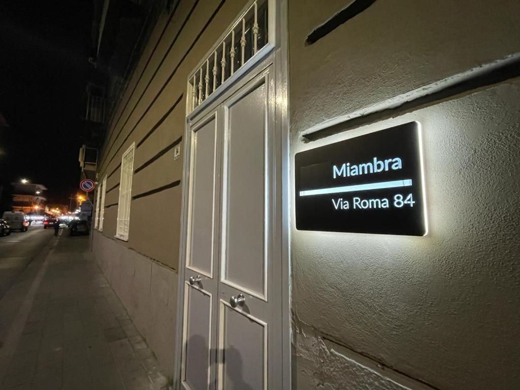 um sinal na lateral de um edifício com uma porta em Miambra 