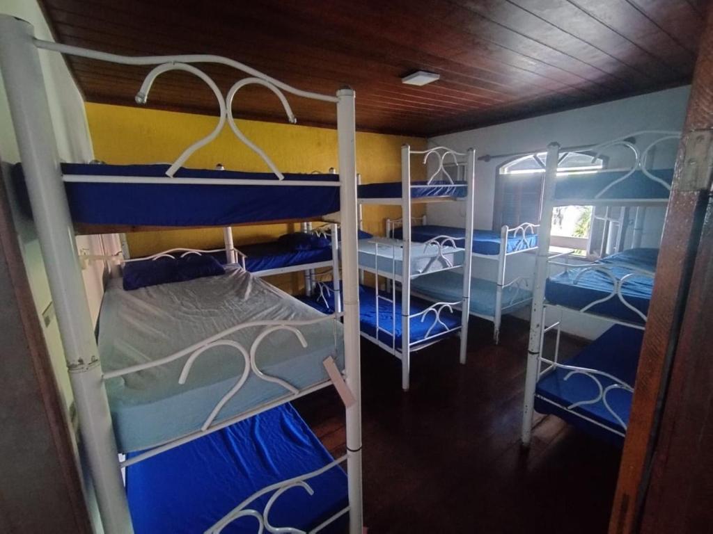 a room with three bunk beds in a house at Hostel Praia Brava in Arraial do Cabo