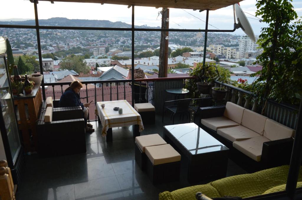 eine Person auf einem Balkon mit Stadtblick in der Unterkunft Terrace Mtatsminda in Tbilisi City